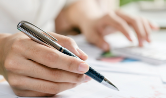 Person writing down notes with a pen.